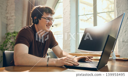 Smiling helpdesk operator consulting client from laptop. Smiling helpdesk operator consulting client from laptop. 139958495