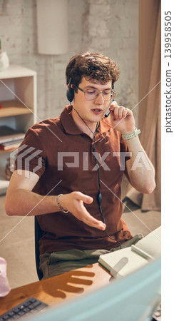 Male support agent speaking with client during service call. Male support agent speaking with client during service call. 139958505
