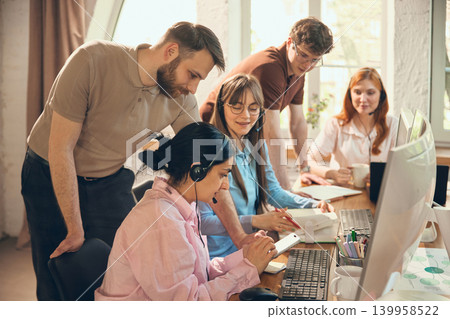 Customer service team checking notes during call center workday. 139958522