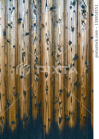 A wood texture background featuring beautiful wood grain visible through vertical planks resembling burnt cedar. 139958551