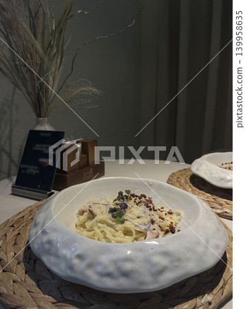Italian pasta carbonara with parmesan, bacon and microgreens in a stylish ceramic plate 139958635