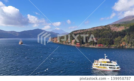 A pirate ship sailing across Lake Ashi amidst the autumn foliage, with Mount Fuji beyond the torii gate of Hakone Shrine. A pirate ship sailing across Lake Ashi amidst the autumn foliage, with Mount Fuji beyond the torii gate of Hakone Shrine. 139958787