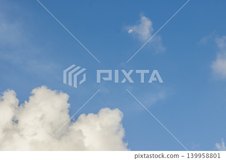 Moon and Clouds in Blue Sky. Nature Background. Celestial Cloudscape. Peaceful Scene. Daylight Weather. High quality photo Moon and Clouds in Blue Sky. Nature Background. Celestial Cloudscape. Peaceful Scene. Daylight Weather. High quality photo 139958801