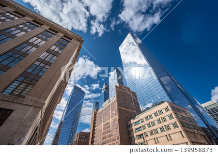 New york, usa august 20,2024. Skyscrapers and modern office buildings reflecting a sunny blue sky with clouds, highlighting urban development and business in manhattan New york, usa august 20,2024. Skyscrapers and modern office buildings reflecting a sunny blue sky with clouds, highlighting urban development and business in manhattan 139958873