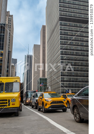 New york, usa august 20,2024. New york city street with towering manhattan skyscrapers, bustling traffic and iconic yellow taxis navigating a busy urban canyon New york, usa august 20,2024. New york city street with towering manhattan skyscrapers, bustling traffic and iconic yellow taxis navigating a busy urban canyon 139958879