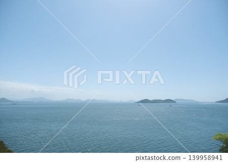 A Seto Inland Sea landscape with islands floating on a blue sky and calm sea. A Seto Inland Sea landscape with islands floating on a blue sky and calm sea. 139958941