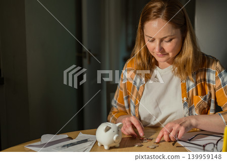 Cost of living crisis concept with worried woman counting coins at home, copy space Cost of living crisis concept with worried woman counting coins at home, copy space 139959148