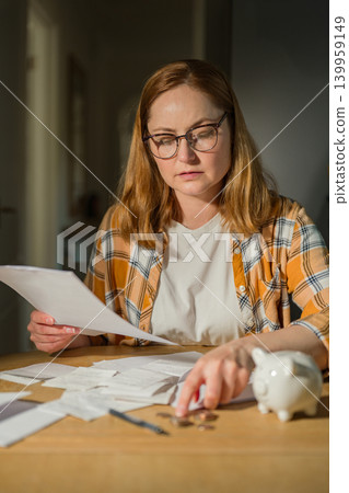 Paying bills and household budgeting concept with thoughtful woman at home, copy space Paying bills and household budgeting concept with thoughtful woman at home, copy space 139959149