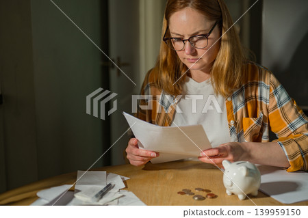 Paying bills and household budgeting concept with thoughtful woman at home, copy space Paying bills and household budgeting concept with thoughtful woman at home, copy space 139959150