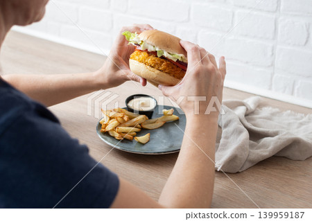 Woman holding crispy chicken burger Woman holding crispy chicken burger 139959187