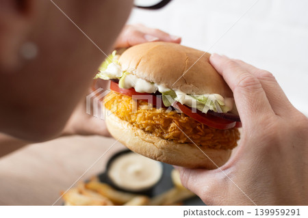 Woman holding crispy chicken burger Woman holding crispy chicken burger 139959291