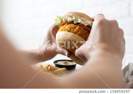 Woman holding crispy chicken burger Woman holding crispy chicken burger 139959297
