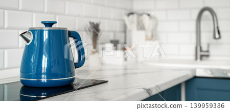 Blue electric kettle in modern white kitchen with marble countertop Blue electric kettle in modern white kitchen with marble countertop 139959386
