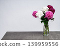 beautiful bouquet of mixed white, pink, and burgundy peonies in a glass vase standing on a grey concrete table with copy space. Variety Festiva Maxima, Sarah Bernhardt, Kansas, Karl Rosenfield. 139959556