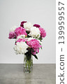 beautiful large bouquet of mixed white, pink, and burgundy peonies in a glass vase standing on a grey concrete table. Variety Festiva Maxima, Sarah Bernhardt, Kansas, Karl Rosenfield. Paeonia 139959557