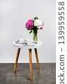bouquet of peonies and two coffee cups on a modern round side table. An element of interior design. 139959558