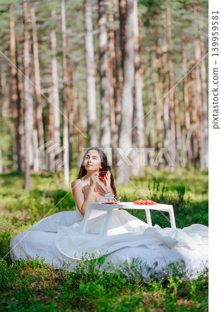 Young woman has breakfast in bed in a summer forest 139959581