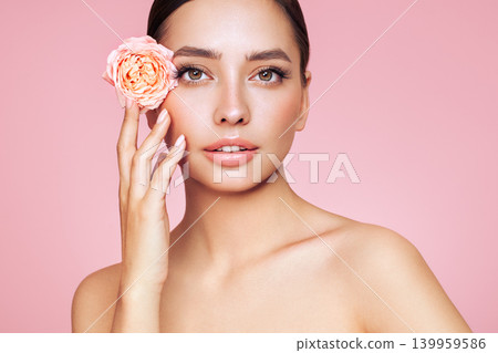 Beautiful young woman with a rose flower 139959586