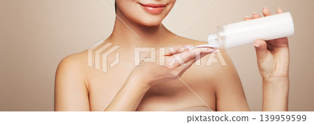 Smiling woman holds bottle with cosmetic tonic 139959599