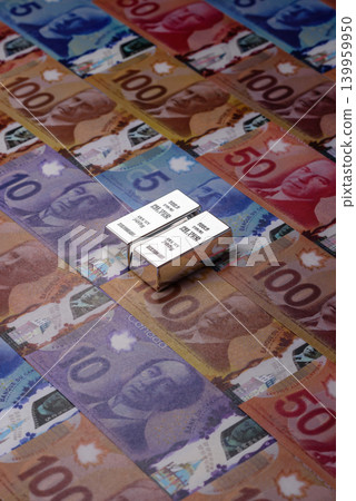 A silver bar, white metal against a backdrop of Canadian money, as a concept. A silver bar A silver bar, white metal against a backdrop of Canadian money, as a concept. A silver bar 139959950