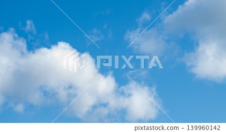 Horizontal panorama of vintage Antonov An2 airplane flying through fluffy white clouds in clear blue sky. Retro soviet aircraft soaring in daytime heavens. Beautiful aviation background filled with 139960142
