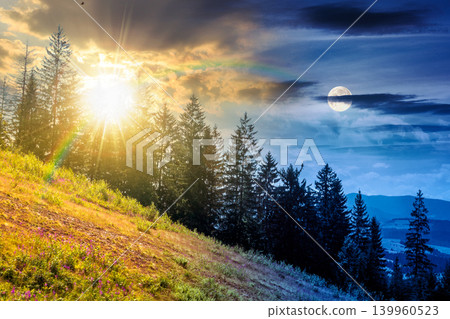 day meet night. view of a hillside of mountain range with coniferous forest and meadow. sun and moon over mountain landscape in summer at twilight. nice picture for earth day or astrology background 139960523
