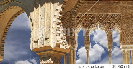 Arches in Islamic (Moorish) style (against the background of a beautiful sky with clouds) in Alhambra, Granada, Spain 139960536