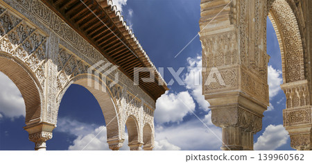 Arches in Islamic (Moorish) style (against the background of a beautiful sky with clouds) in Alhambra, Granada, Spain Arches in Islamic (Moorish) style (against the background of a beautiful sky with clouds) in Alhambra, Granada, Spain 139960562