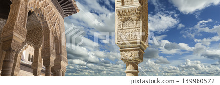 Arches in Islamic (Moorish) style (against the background of a beautiful sky with clouds) in Alhambra, Granada, Spain Arches in Islamic (Moorish) style (against the background of a beautiful sky with clouds) in Alhambra, Granada, Spain 139960572
