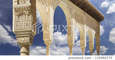 Arches in Islamic (Moorish) style (against the background of a beautiful sky with clouds) in Alhambra, Granada, Spain Arches in Islamic (Moorish) style (against the background of a beautiful sky with clouds) in Alhambra, Granada, Spain 139960579