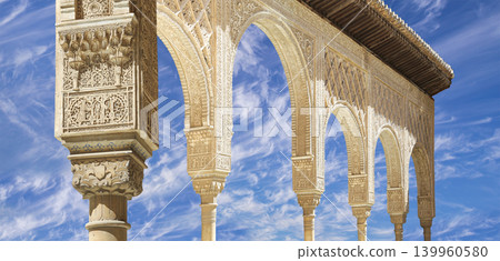 Arches in Islamic (Moorish) style (against the background of a beautiful sky with clouds) in Alhambra, Granada, Spain Arches in Islamic (Moorish) style (against the background of a beautiful sky with clouds) in Alhambra, Granada, Spain 139960580