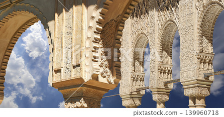 Arches in Islamic (Moorish) style (against the background of a beautiful sky with clouds) in Alhambra, Granada, Spain 139960718
