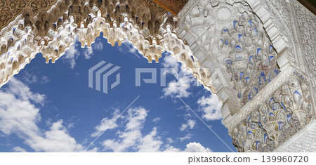 Arches in Islamic (Moorish) style (against the background of a beautiful sky with clouds) in Alhambra, Granada, Spain Arches in Islamic (Moorish) style (against the background of a beautiful sky with clouds) in Alhambra, Granada, Spain 139960720