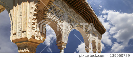 Arches in Islamic (Moorish) style (against the background of a beautiful sky with clouds) in Alhambra, Granada, Spain 139960729