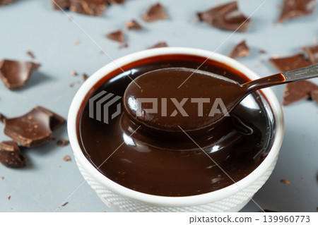 Smooth melting chocolate sauce flowing from a spoon 139960773
