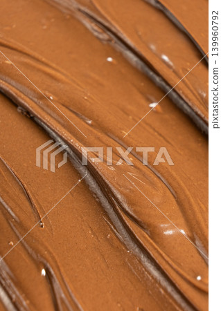 Macro texture of glossy chocolate nut cream swirling patterns Macro texture of glossy chocolate nut cream swirling patterns 139960792