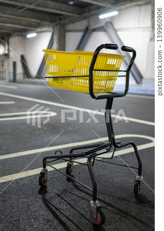 一輛黃色購物車放置在室內停車場。 一輛黃色購物車放置在室內停車場。 139960906