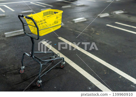 A yellow shopping cart placed in an indoor parking lot A yellow shopping cart placed in an indoor parking lot 139960910