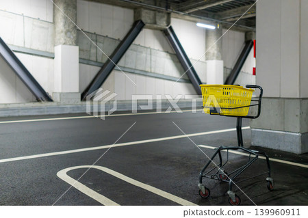 A yellow shopping cart placed in an indoor parking lot A yellow shopping cart placed in an indoor parking lot 139960911