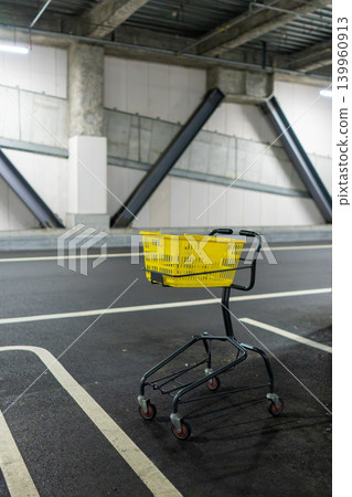一輛黃色購物車放置在室內停車場。 一輛黃色購物車放置在室內停車場。 139960913