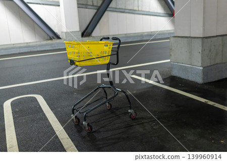 一輛黃色購物車放置在室內停車場。 一輛黃色購物車放置在室內停車場。 139960914
