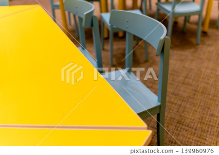 A colorful interior space with a yellow table and light blue chairs. A colorful interior space with a yellow table and light blue chairs. 139960976