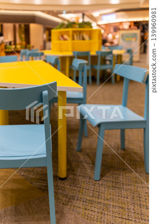 A colorful interior space with a yellow table and light blue chairs. A colorful interior space with a yellow table and light blue chairs. 139960981