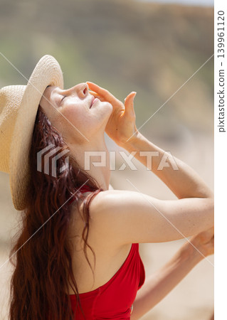 Woman applies sunscreen on her skin while relaxing at the beach during a sunny day Woman applies sunscreen on her skin while relaxing at the beach during a sunny day 139961120