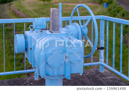 Blue sluice gate operating handle installed along the river Blue sluice gate operating handle installed along the river 139961498