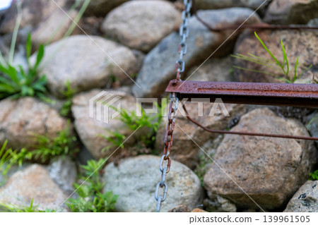 一架鏽跡斑斑的金屬鏈梯懸掛在石牆上。 139961505