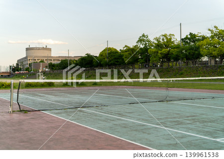 黃昏時分,河岸邊空無一人的網球場。 黃昏時分,河岸邊空無一人的網球場。 139961538