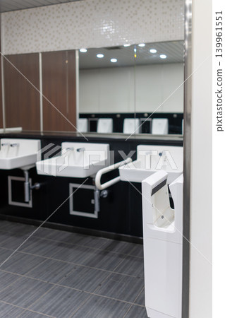 Men's restroom in a commercial facility with striking wood-grain panels. Men's restroom in a commercial facility with striking wood-grain panels. 139961551