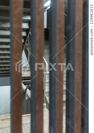 透過豎桿看到的消防逃生通道的工業背景素材。 139961615