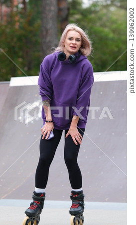 Cute blonde feels free and light while roller skating alone in city park. Stunning Caucasian woman with beautiful figure uses roller skates for outdoor sports. Cute blonde feels free and light while roller skating alone in city park. Stunning Caucasian woman with beautiful figure uses roller skates for outdoor sports. 139962002